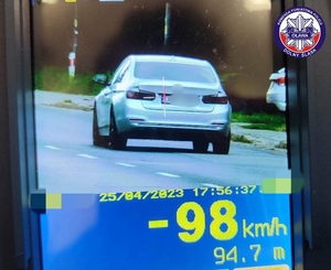 zdjęcie z laserowego miernika prędkości na którym widać szary samochód marki bmw oraz jego pomiar prędkości tj. 98 km/h w terenie zabudowanym