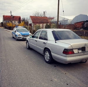 Na zdjęciu widać radiowóz oraz zatrzymany do kontroli drogowej samochód osobowy marki Mercedes koloru srebrnego (zasłonięte tablice rejestracyjne), którego kierowca okazał się osobą nietrzeźwą