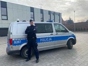 Policjant, który ugasił palącego się mężczyznę stoi przy policyjnym radiowozie