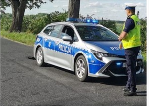 policjant Ruchu Drogowego stojący przy radiowozie policji