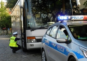 policjant sprawdza stan techniczny autobusu