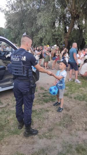 Policjant rozdaje odblaski osobie małoletniej