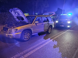 na zdjęciu widać policyjny radiowóz oraz samochód osobowy marki Subaru zatrzymany po pościgu