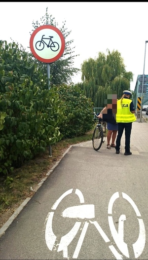 na zdjęciu funkcjonariusz Ruch Drogowego kontroluje rowerzystę, który poruszał się ul. Oleśnicką wbrew obowiązującemu zakazowi ruchu rowerów