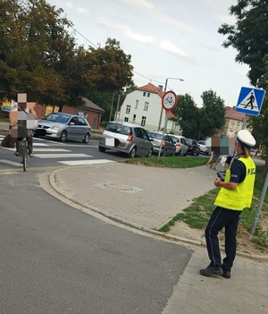 Policjant Ruchu Drogowego podczas działań na ul. Strzelnej w Oławie - kontrola przestrzegania przepisów ruchu drogowego przez pieszych i rowerzystów