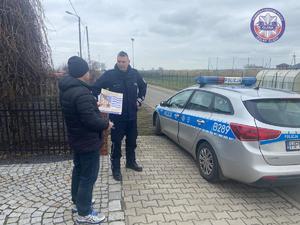 policjant rozmawia z mieszkańcem gminy Domaniów na temat służby w Policji