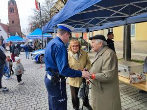 Policjant z Wydziału Ruchu Drogowego KWP we Wrocławiu rozdający odblaski mieszkańcom miasta Oława