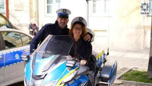 Policjant z Wydziału Ruchu Drogowego KWP we Wrocławiu podczas zdjęcia z mieszkanką powiatu siedzącą na policyjnym motorze
