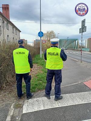 Policjant z Ogniwa Ruchu Drogowego oławskiej jednostki wspólnie z funkcjonariuszem Straży Miejskiej w Oławie kontrolują przestrzeganie przepisów ruchu drogowego przez rowerzystów