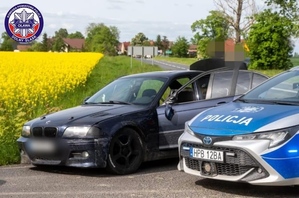 policyjny oznakowany radiowóz oraz zatrzymany po pościgu samochód marki BMW koloru czarnego