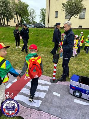 policjantka pokazująca na miasteczku umiejętności drogowych jak właściwie przechodzić przez pasy