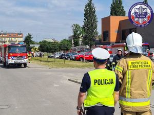 policjant z Ogniwa Ruchu Drogowego oraz strażak podczas zabezpieczenia drogi dojazdu na miejsce ewakuacji - ćwiczenia dowódczo-sztabowe