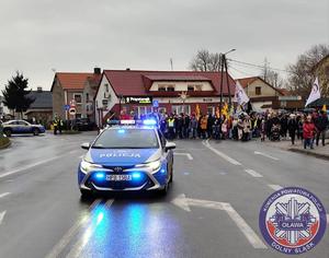 oznakowany policyjny radiowóz na tle oławskiego Orszaku Trzech Króli