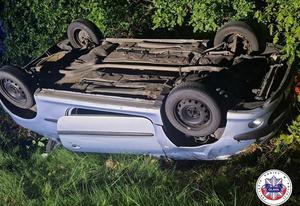 samochód marki peugeot leżący w rowie na dachu