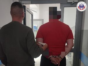 zatrzymany mężczyzna prowadzony przez policjanta z Wydziału Kryminalnego
