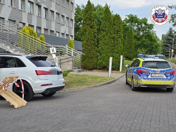 policyjny oznakowany radiowóz znajdujący się przy szpitalu, do którego eskortowano samochód z kobietą w stanie zagrożenia życia