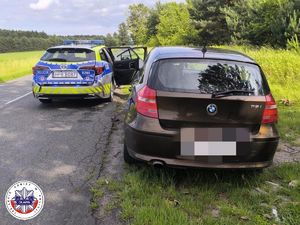 oznakowany policyjny radiowóz oraz samochód osobowy marki bmw koloru czarnego podczas kontroli drogowej