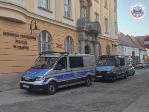 Policyjne oznakowane radiowozy zaparkowane przed budynkiem oławskiej komendy Policji