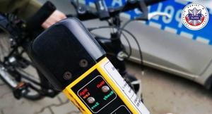 rower, napis policja oraz urządzenie do pomiaru stanu trzeźwości