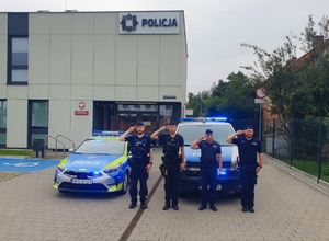 Policjanci salutujący przy radiowozach podczas godziny W