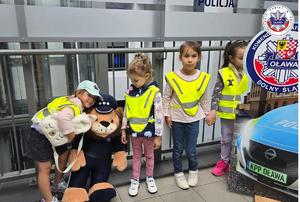 przedszkolaki na zdjęciu z pluszową maskotką komisarza lwa