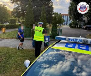 policjant rozdający pod szkołą odblaski