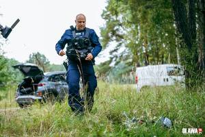 policjant sprawdzający zawartość plecaka