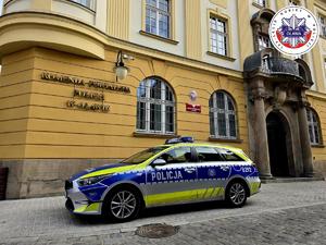 Policyjny oznakowany radiowóz przy budynku oławskiej Policji