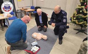 seniorzy obsługujący ćwiczebne urządzenie AED