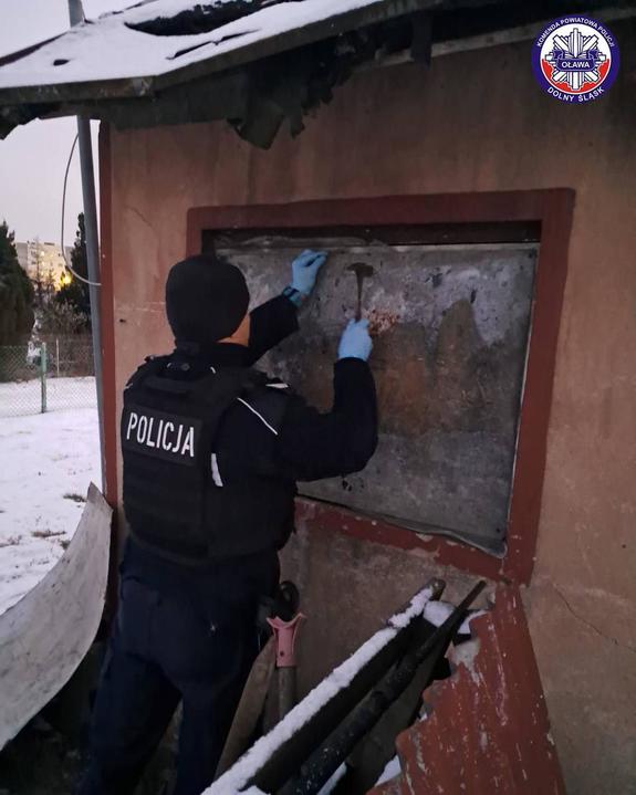 Policjant naprawiający okno w altance