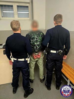 Policjanci prowadzący osobę zatrzymaną