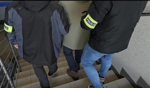 Policjanci prowadzą zatrzymanego mężczyznę