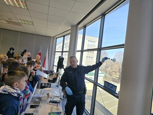 technik kryminalistyki pokazujący dzieciom jak pobrać odciski palców