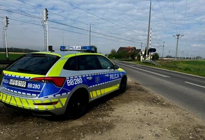 policyjny oznakowany radiowóz przy przejeździe kolejowym