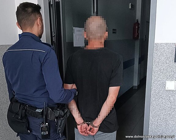 zatrzymany mężczyzna prowadzony przez policjanta