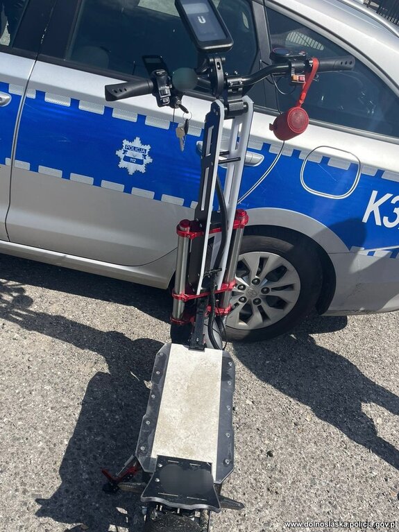 hulajnoga elektryczna i policyjny radiowóz - zdjęcie poglądowe